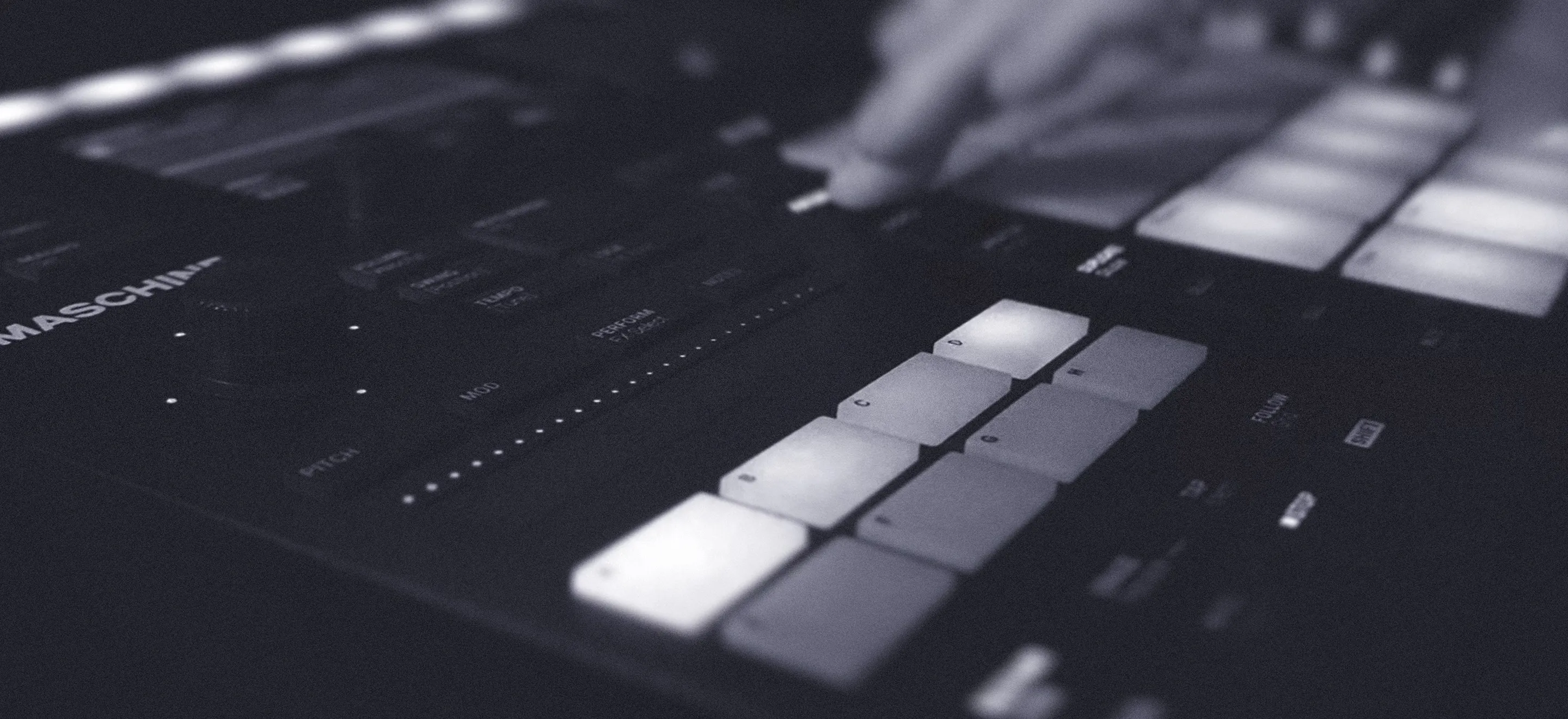A person interacts with a music controller, playing the keyboard and exploring music production.